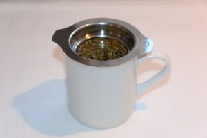 Infuseur en acier inoxydable dans une tasse.