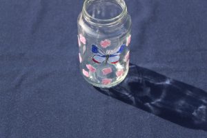 Pot de verre décoré de motifs collés.